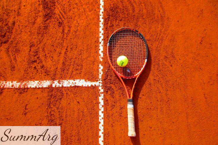 Tennis racket and ball on red clay court, ideal for sports-themed content.