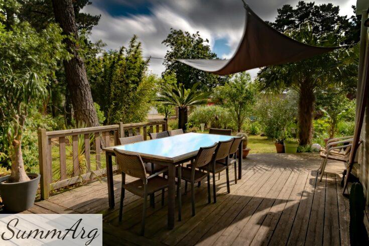 brown wooden table with chairs and umbrella