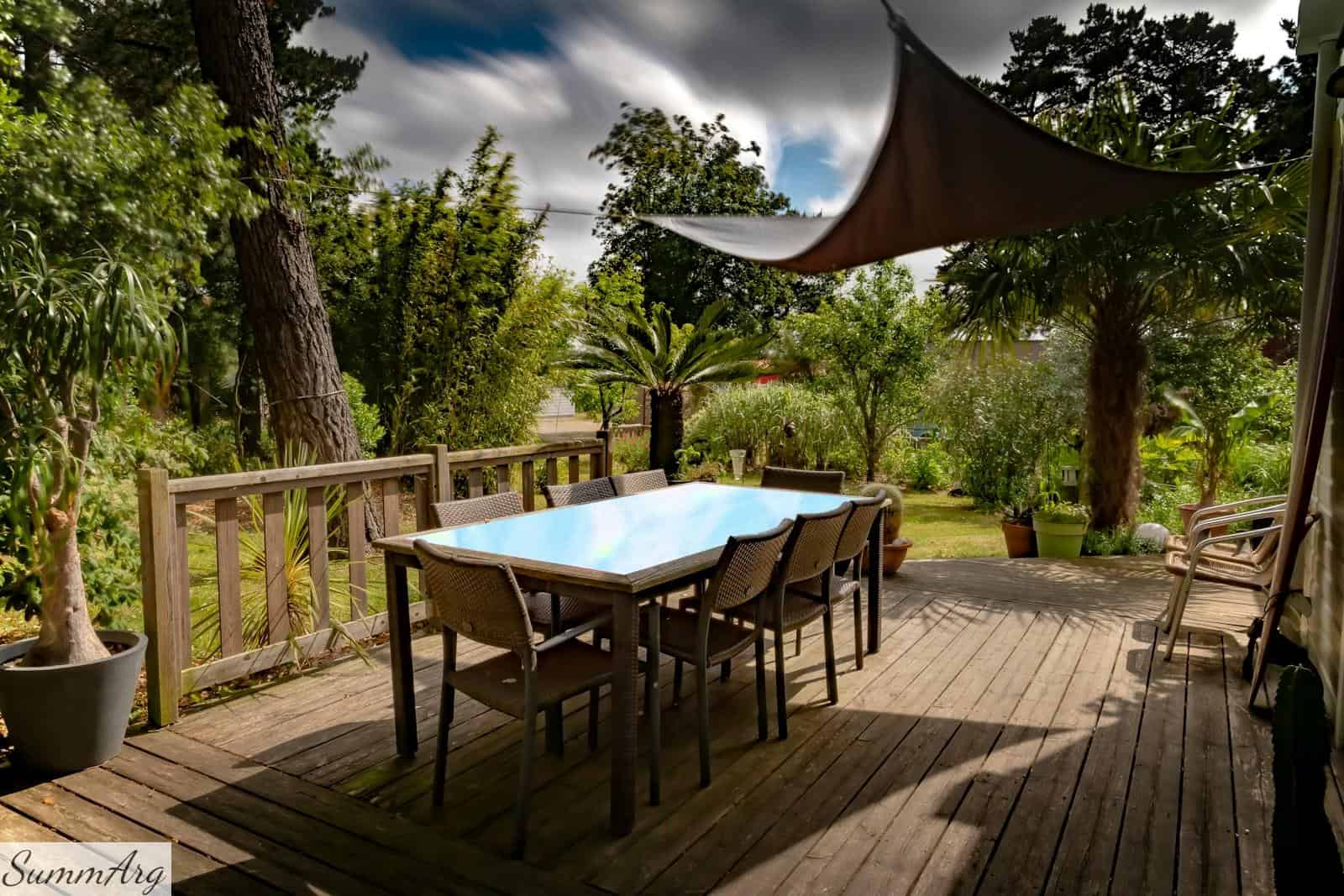brown wooden table with chairs and umbrella